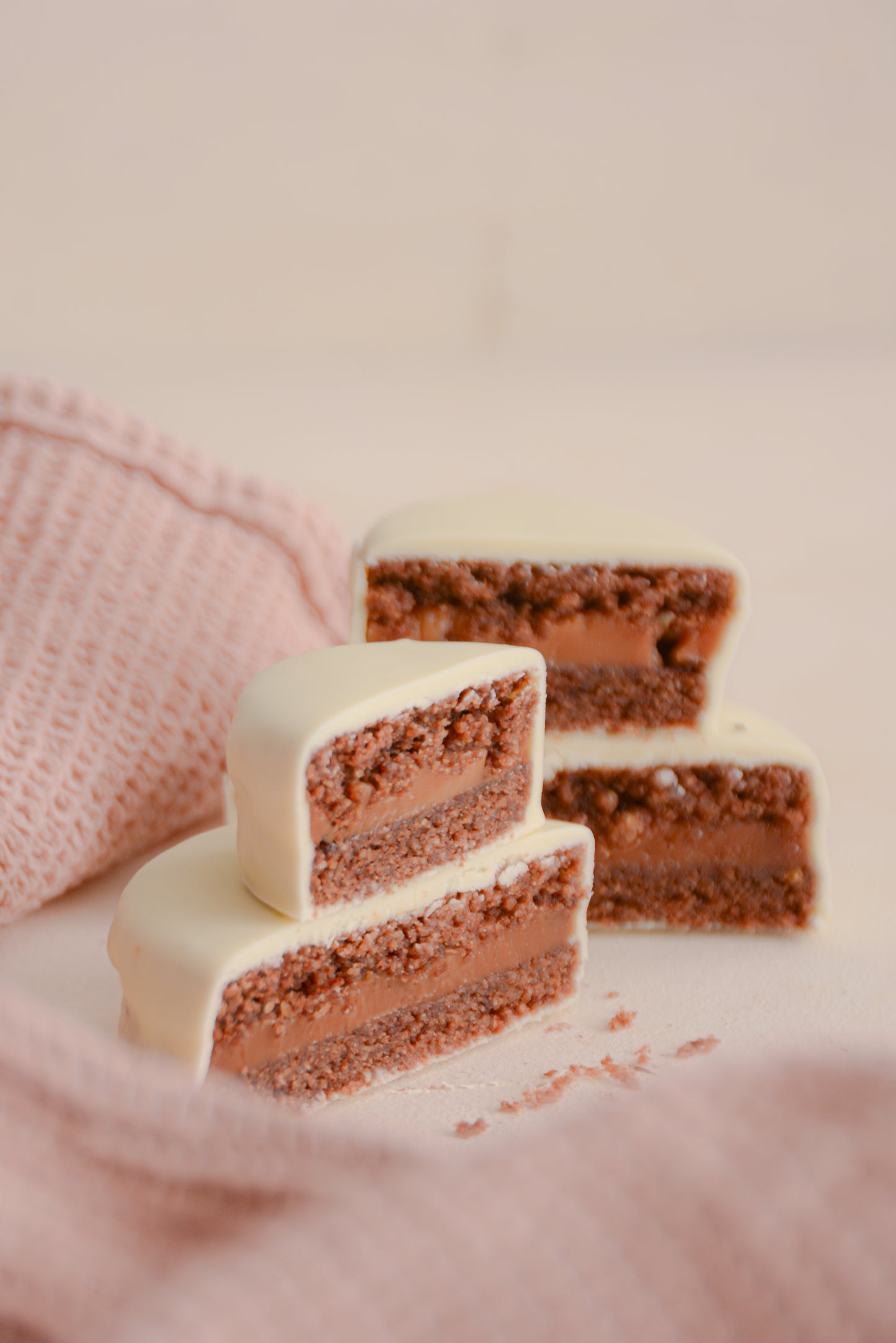 Alfajores de cacao con dulce de leche bañados en chocolate blanco